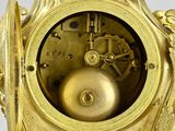 a gold clock that is sitting on a table