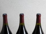 three bottles of wine sitting on a table next to each other