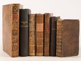 plusieurs vieux livres sont empilés sur une surface blanche