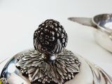 a silver plate with a black berry on top of it
