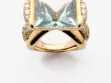 an image of a gold ring with a blue topaz stone and diamonds