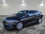 une voiture noire garée dans un garage au sol en damier