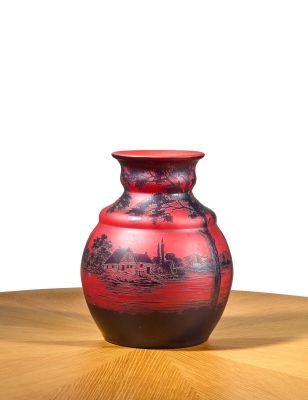 a red vase sitting on top of a wooden table