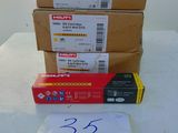 three boxes of staples are sitting on a table next to a piece of paper