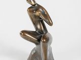une statue en bronze d'un homme assis sur un rocher