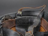 a black bucket with a leather belt and a pair of scissors in it