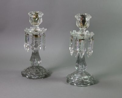 pair of clear glass candlesticks on a grey background