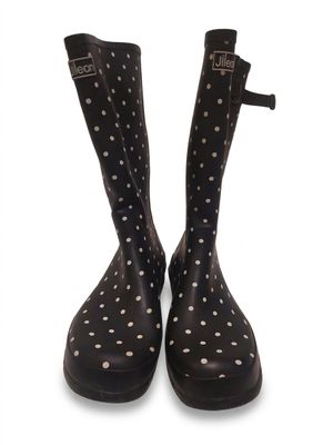 des bottes de pluie noires ornées de pois blancs sur fond blanc