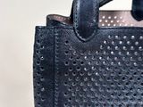 a close up of a black bag with holes on it
