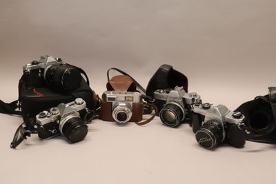 a lot of different types of cameras sitting on a table