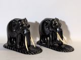 deux éléphants noirs avec des défenses sur un fond blanc