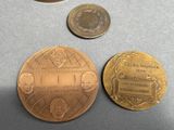 two gold coins and a coin with a picture of a man ' s face on it