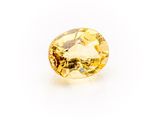 a yellow sapphire stone on a white background