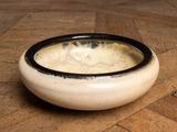 a black and white bowl of soup on a wooden table