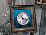 une photo d'une horloge posée sur une table en verre