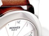 a close up of a watch with a brown leather strap
