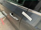 a silver car with a sticker on the side of it