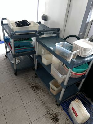 a kitchen with a sink and a cart with dishes on it