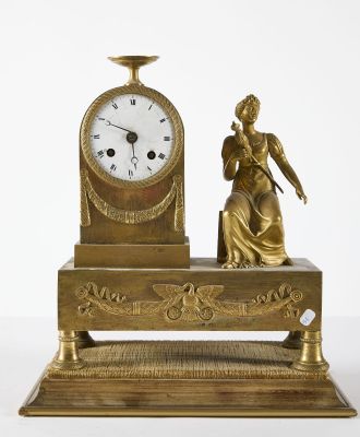a gold clock with a statue on top of it