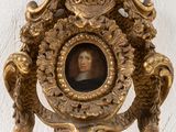 a gold clock with a picture of a man on it
