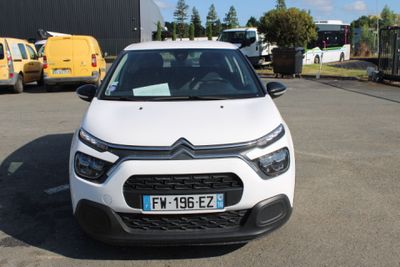 une petite voiture blanche garée dans un parking