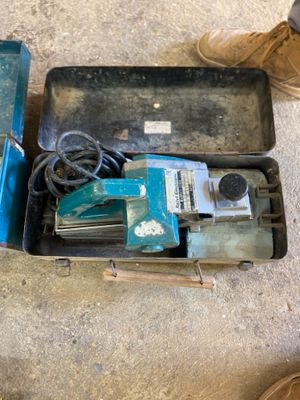 two tools in a case on the floor next to a pair of shoes