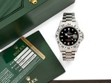un gros plan d'une montre Rolex avec son coffret et ses papiers