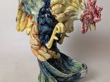 a figurine of a rooster with a flower in its beak