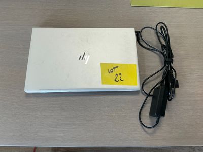 a white laptop computer sitting on a table with a yellow sticker on it