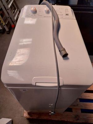 une machine à laver blanche posée sur une palette