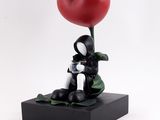 statue d'un chat noir et blanc tenant un ballon rouge en forme de cœur