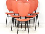 six chaises orange aux pieds noirs, sur fond blanc