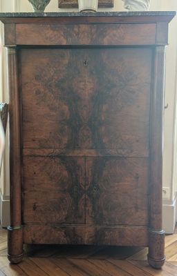 a wooden cabinet with a marble top on a hard wood floor