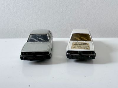 deux petites voitures posées sur une table