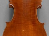 an antique violin with a wooden back and bow on a stand