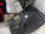 a bag of luggage sitting on a bed next to a bag of clothes