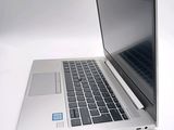 a silver laptop computer sitting on a white surface