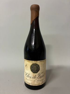 an old bottle of wine sitting on top of a table