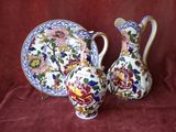 deux vases et une assiette posés sur une nappe rouge