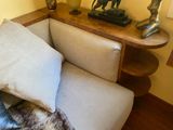 a couch with a pillow and a table with a lamp on it