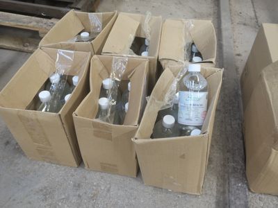 plusieurs bouteilles d'eau dans un carton posé par terre