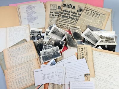 a pile of old papers and old photos on a table