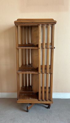 une grande armoire en bois avec une porte vitrée, montée sur roulettes
