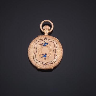 un gros plan d'une montre de poche en or ornée d'un oiseau bleu