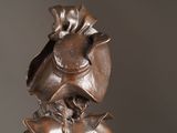 a bronze statue of a man with a hat and bow tie