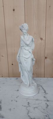 statue en marbre représentant une femme tenant un vase posé sur une table en marbre
