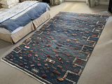 a bedroom with a bed and a rug on the floor