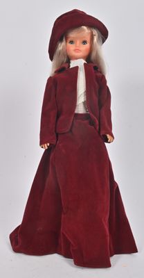 une poupée vêtue d'une robe rouge et d'un chapeau