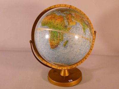 un globe terrestre posé sur un socle, sur une table