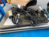 a laptop computer sitting on top of a table with a charger on top of it